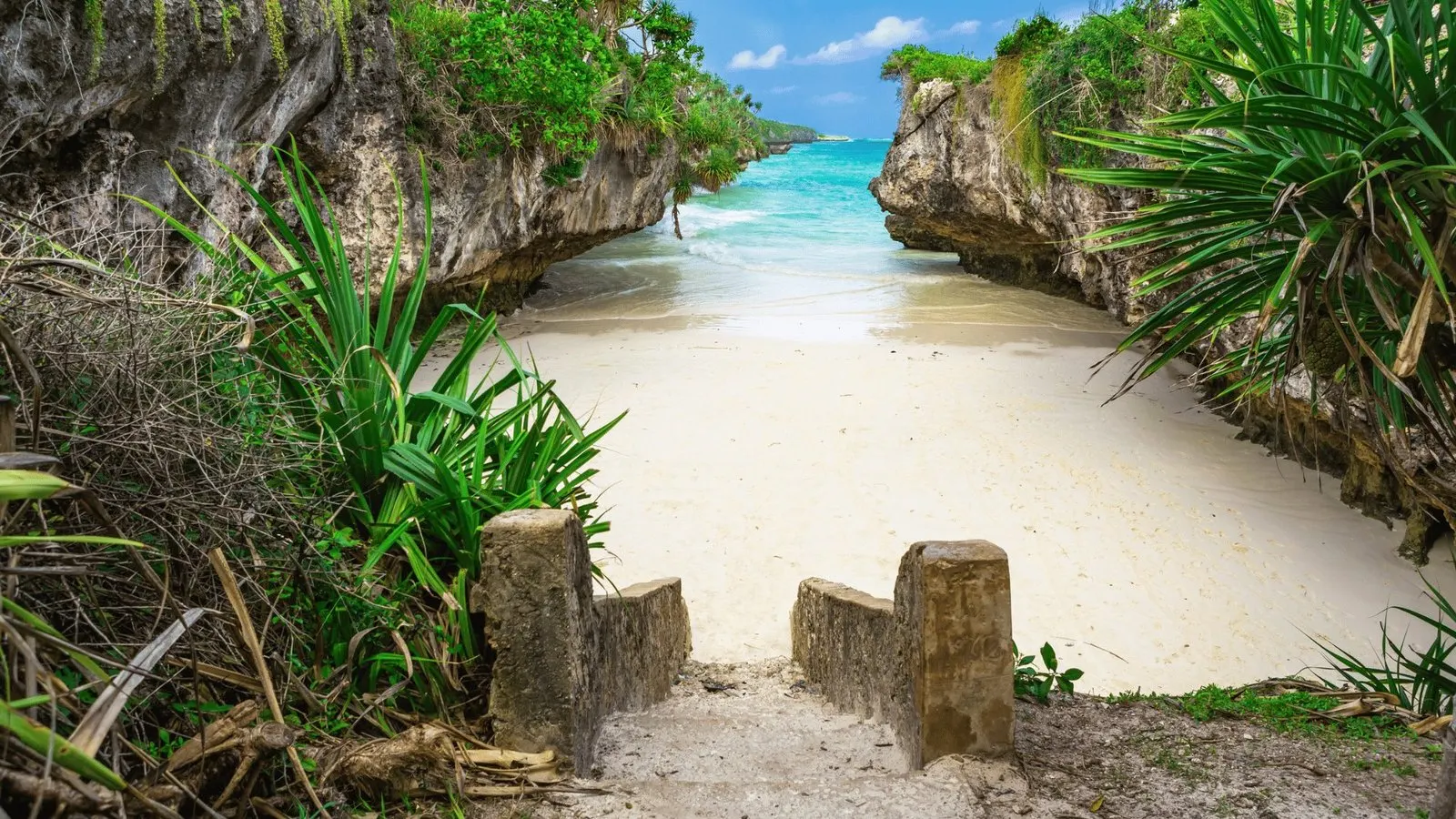 Weißer Strand zwischen Felsen auf Sansibar